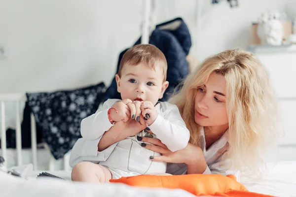 Anne yatak odasında bebeğiyle oynuyor. — Stok fotoğraf