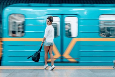 Metro istasyonunda poz veren güzel genç kız.