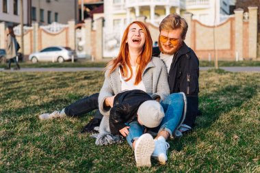 Mutlu anne ve baba parkta sarılıyor.