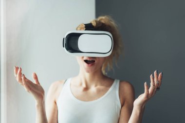 VR kulaklıklı kadın yukarı bakıyor.