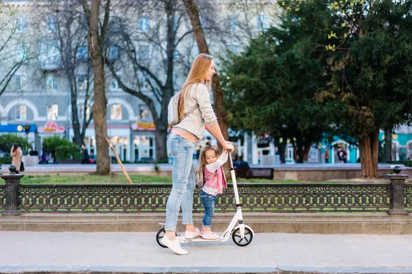 Mom and little daughter on a scooter — Stock Photo, Image