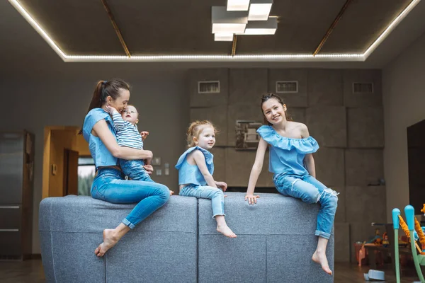 Mamma, två döttrar och en liten son på soffan. — Stockfoto