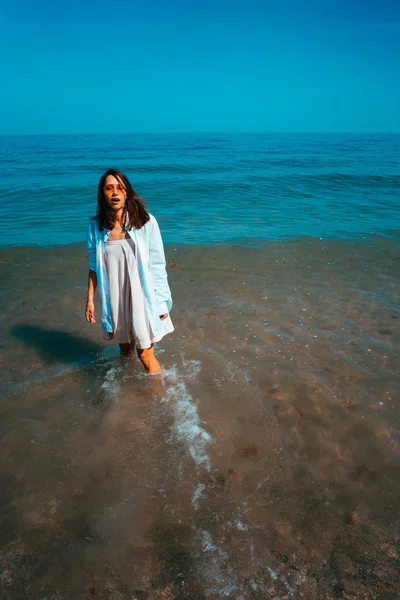 A rapariga está no mar junto à costa. — Fotografia de Stock