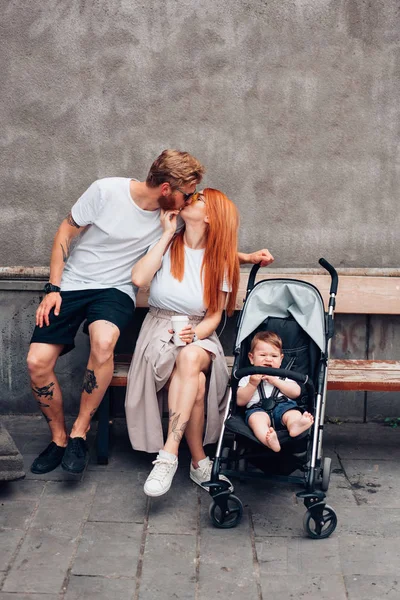 Anne, baba ve çocuk arabası içinde küçük oğlu