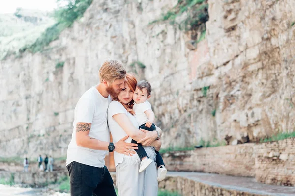 A família de pé perto de uma parede de pedra — Fotografia de Stock