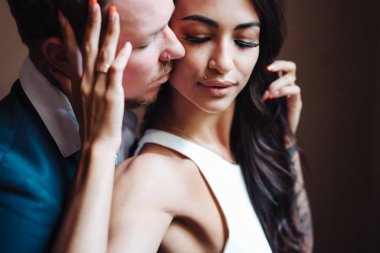 İçeride kameraya poz veren güzel, genç bir çift.