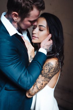 İçeride kameraya poz veren güzel, genç bir çift.