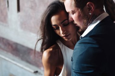 İçeride kameraya poz veren güzel, genç bir çift.