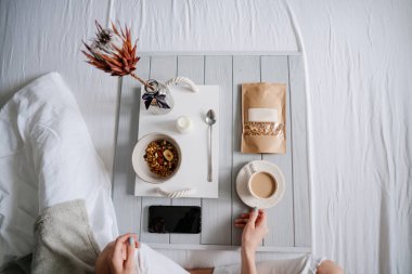 Yatakta mısır gevreği yiyen kadın