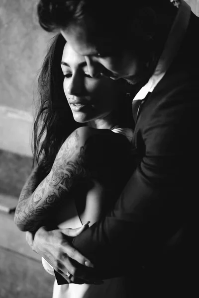 İçeride kameraya poz veren güzel, genç bir çift.