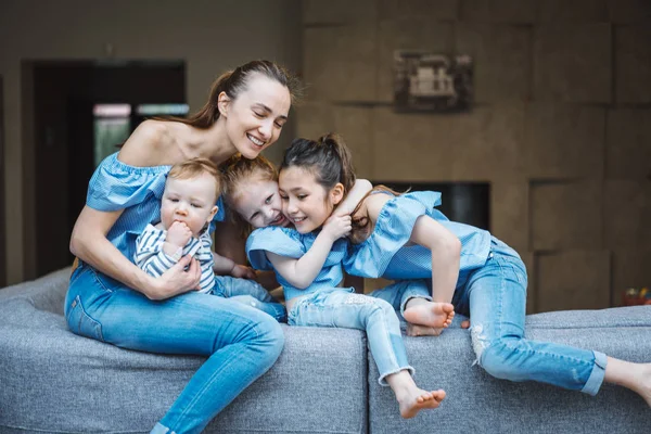 Anne, iki kız ve küçük bir oğlan kanepede. — Stok fotoğraf