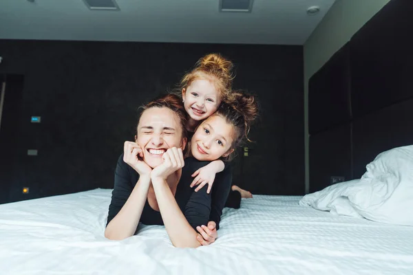 Anya és két lánya jól érzik magukat az ágyon. — Stock Fotó