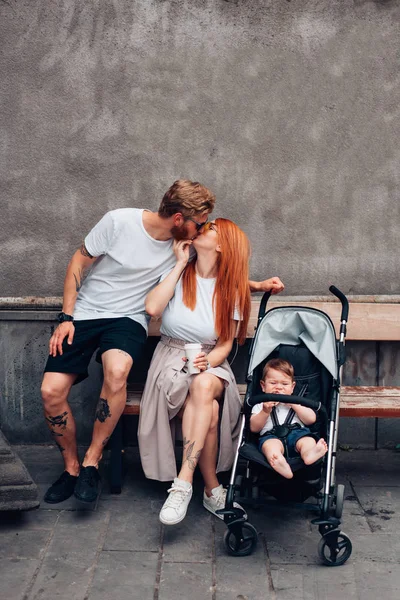 Mom, Dad and little son in a pram — Stock Photo, Image