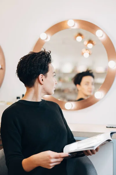 Donna attraente allo specchio in studio di bellezza — Foto Stock