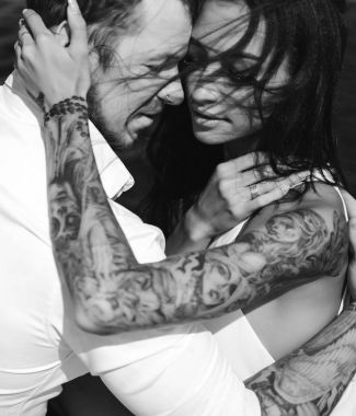 Genç çift deniz kıyısındaki iskelede oturuyor.