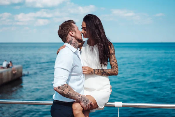 Guy et fille sur la jetée de la mer — Photo