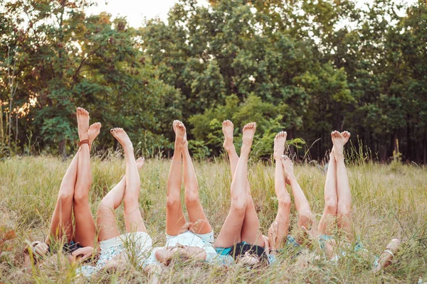 여섯 소녀 가 풀밭에 누워 다리를 치켜들고 있다 — 스톡 사진