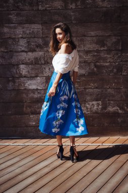 Ahşap bir duvarın arkasında duran kadın.