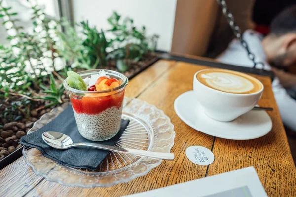 Cappuccino con cuchara en taza y postre — Foto de Stock
