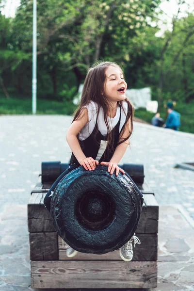 Préscolaire fille assis sur le dessus d'un canon — Photo