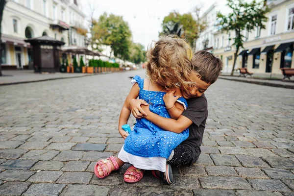 Little boy and girl are sitting on the street — Stock Photo, Image