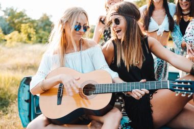Kızlar gövdede bir gitarla oturuyorsun