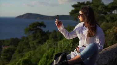 güzel kız fotoğrafları telefonda alır.
