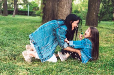 Anne ve kızı çimlerin üstünde iyi eğlenceler