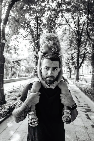 Liten flicka ridning på pappor hals — Stockfoto