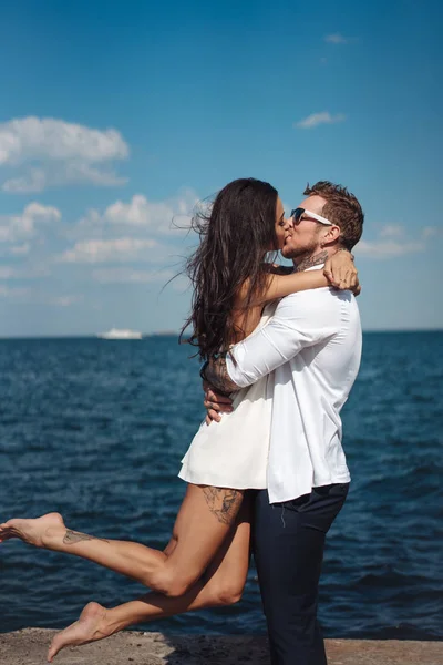 Guy et fille sur la jetée de la mer — Photo