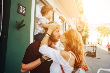 Mutlu ebeveynler dışarıda oğluyla oynuyorlar.