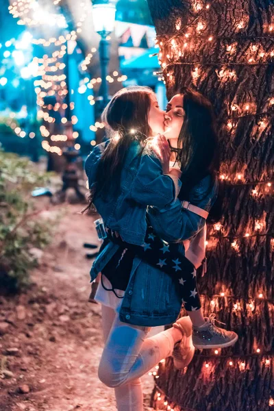 Мама целует свою дочь в вечернем парке — стоковое фото