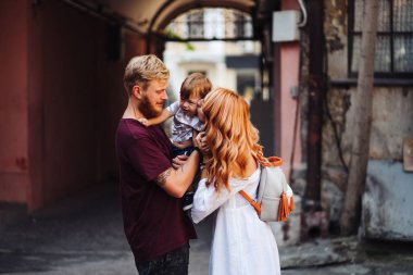 Mutlu ebeveynler dışarıda oğluyla oynuyorlar.