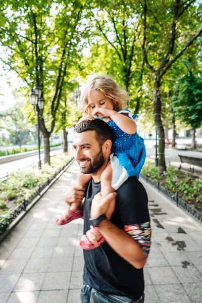 Kleines Mädchen reitet auf Papas Hals — Stockfoto