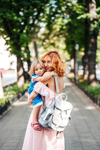 Woman hugs her daughter, holding her in her arms — Stock Photo, Image