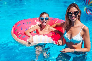 Annesiyle yüzme havuzunda küçük bir kız.