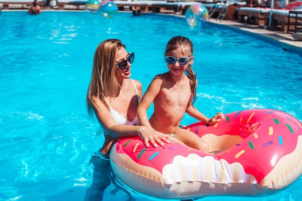 Annesiyle yüzme havuzunda küçük bir kız.