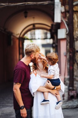 Mutlu ebeveynler dışarıda oğluyla oynuyorlar.