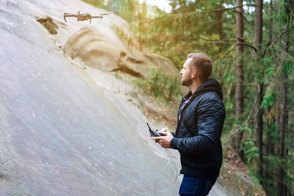 Mec commence un quadrocopter dans la forêt — Photo