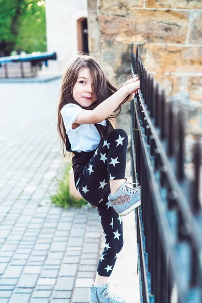 Malá holčička hraje na plot — Stock fotografie