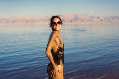 Genç bir kadın doğal mineral çamurunun tadını çıkarıyor.