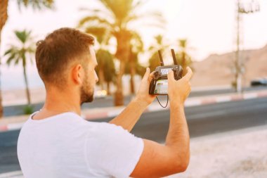 Adam uzaktan kumandayla dronu kontrol ediyor.