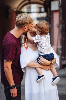 Mutlu ebeveynler dışarıda oğluyla oynuyorlar.