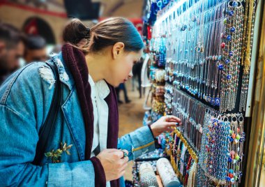 Genç kız turist hediyelik eşya pazarında yürüyor.