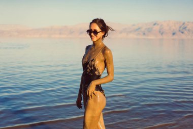 Genç bir kadın doğal mineral çamurunun tadını çıkarıyor.