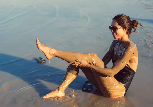 Uma jovem mulher desfrutando da lama mineral natural — Fotografia de Stock