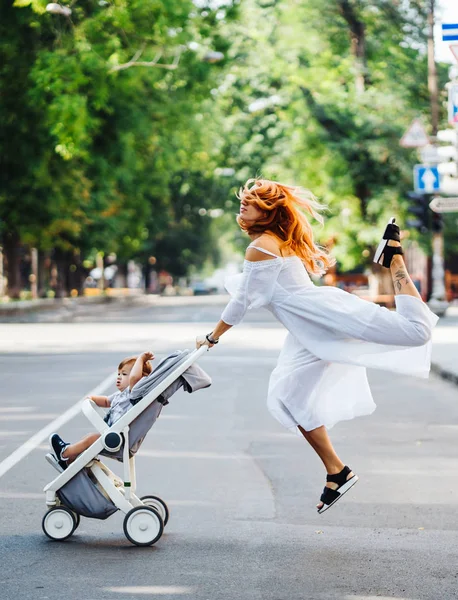 Mamá con un cochecito cruza la calle — Foto de Stock
