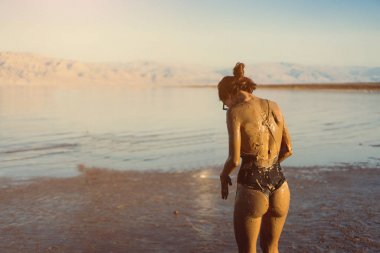 Genç bir kadın doğal mineral çamurunun tadını çıkarıyor.