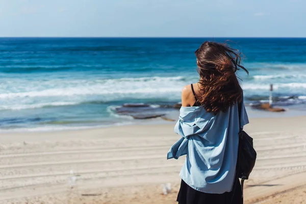 Jovem menina bonita olha para longe no mar — Fotografia de Stock