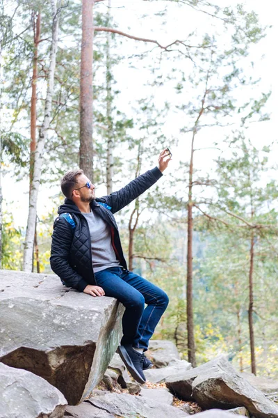 Mec est assis dans les bois sur un rocher — Photo